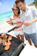 Cheerful couple in holidays preparing grilled meat
