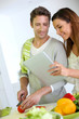 Couple in home kitchen looking for lunch recipe