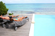 Couple relaxing in long chairs in front of the sea