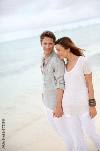 Photo: Romantic couple walking on the beach Romantic couple walking on the beach