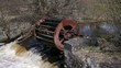 old inoperative water mill on river background