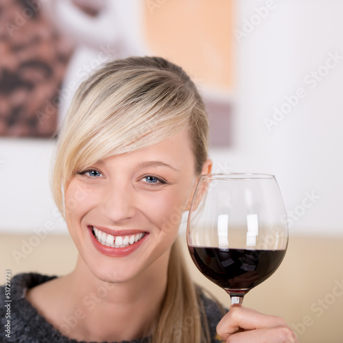 Photo: lächelnde frau stößt mit rotwein an lächelnde frau stößt mit rotwein an