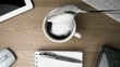 Sugar in teaspoon falling into cup of coffee on a desk
