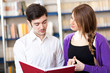 Couple of students reading a book