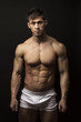 Muscular young man over black