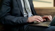 Closeup of businessman typing on laptop computer, steadycam shot