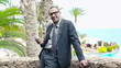 Portrait of businessman in tourist resort texting message on cel