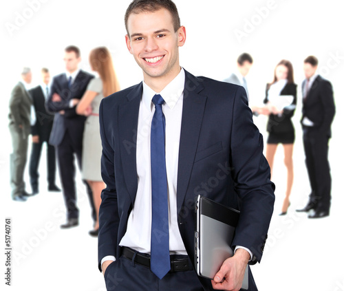 Photo: smart businessman using laptop with colleagues in the background smart businessman using laptop with colleagues in the background