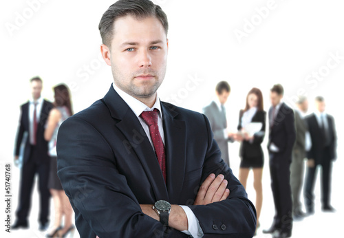 Photo: Handsome happy businessman with colleagues at the back Handsome happy businessman with colleagues at the back