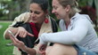 Video: Female friends enjoying smartphone in the park, steadicam shot Female friends enjoying smartphone in the park, steadicam shot