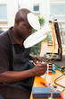 Photo: senior african technician repairing circuit board senior african technician repairing circuit board