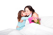 Foto: Child gives flowers and kiss to mom in bed Child gives flowers and kiss to mom in bed