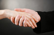 Priest holding woman hand, on black background