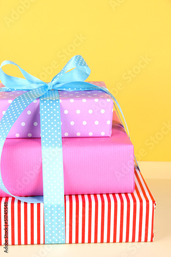 Photo: Gift box tied with a ribbon on a colored background Gift box tied with a ribbon on a colored background