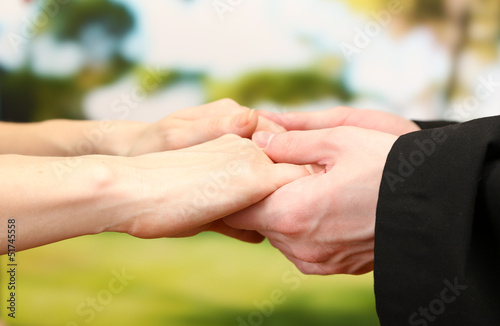 Photo: Priest holding woman hands, on green background Priest holding woman hands, on green background