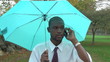 Business man on phone, walking under umbrella