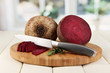 Sliced beetroot on board on wooden table on window background