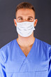 Doctor over dark background in blue shirt