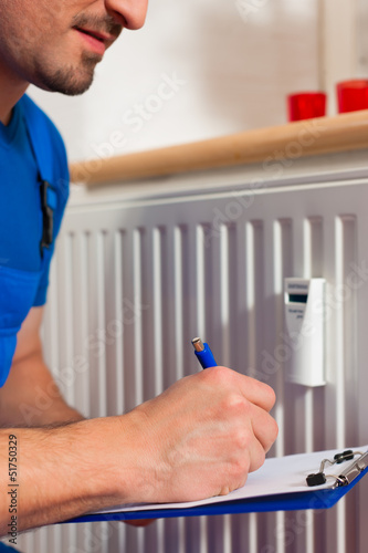 Photo: Technician reading the heat meter Technician reading the heat meter