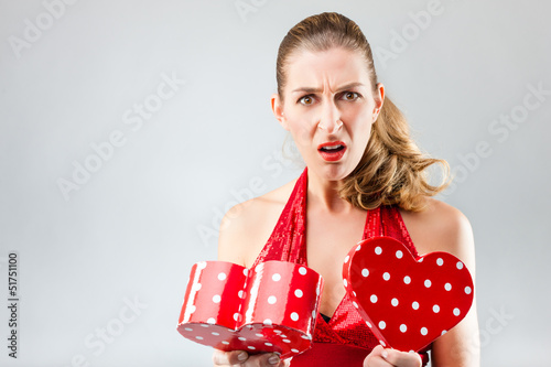 Photo: Woman opening the gift and is disappointed Woman opening the gift and is disappointed