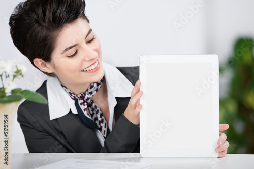 Photo: frau an der rezeption zeigt leeres tablet frau an der rezeption zeigt leeres tablet