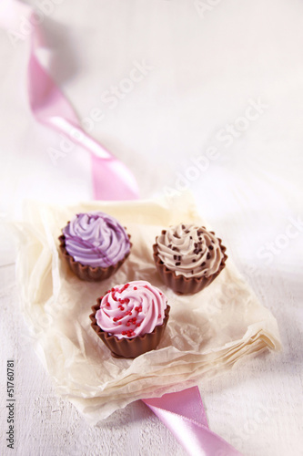 Photo: drei pralinen in cupcake form, rosa, lila und braun drei pralinen in cupcake form, rosa, lila und braun