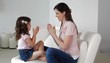 Caucasian mother and daughter clapping hands