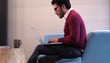 Hispanic man in creative space typing on laptop