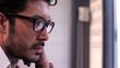 Hispanic man working with laptop reflecting in glasses
