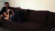 Japanese couple on sofa laughing and sharing mobile device