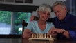 Senior Caucasian couple at home playing chess