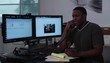 Young man at workstation conversing on telephone