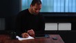Mature man working with digital tablet and making notes
