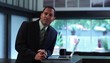 Businessman at counter in creative space with laptop