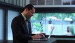 Businessman at counter in creative space typing on laptop