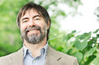 Portrait of happy middle-aged businessman looking at camera and