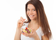 Beautiful young woman eating fruits