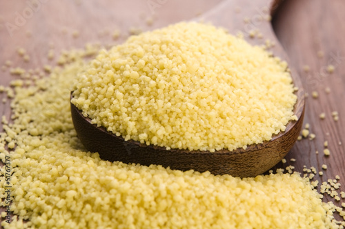 Photo: couscous in wooden spoon on kitchen table couscous in wooden spoon on kitchen table