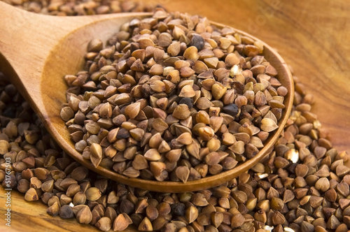 Photo: Buckwheat seeds on wooden spoon in closeup Buckwheat seeds on wooden spoon in closeup