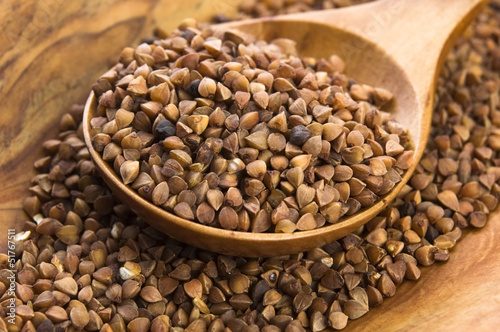 Photo: Buckwheat seeds on wooden spoon in closeup Buckwheat seeds on wooden spoon in closeup