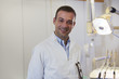 Portrait of happy caucasian dentist smiling at camera