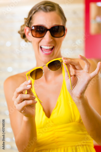 Photo: Young woman at optician with sunglasses Young woman at optician with sunglasses