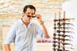 Photo: Young man at optician buying sun glasses Young man at optician buying sun glasses
