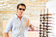 Photo: Young man at optician buying sun glasses Young man at optician buying sun glasses