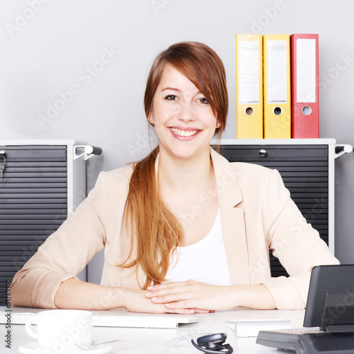 Photo: Female office assistant is satisfied with her job Female office assistant is satisfied with her job