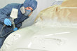 Worker painting car.
