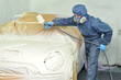 Worker painting car.