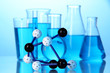 Molecule model and test tubes with liquid on blue background