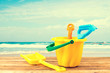 Beach items on wooden deck over sea background