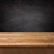 Empty wooden deck table over chalkboard